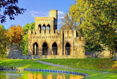 Schloss auf einem Hügel mit Blick auf einen Teich in Wiesbaden, umgeben von viel Grün und malerischer Landschaft