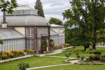 Historisches Gewächshaus in Deutschland mit einem großen Gebäude mit Glasdach und Rasen.