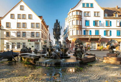Ein Brunnen im Zentrum des Kaiserslauterner Stadtplatzes, umgeben von Architektur