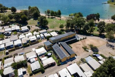 Das Bild zeigt eine Häusergruppe, die an einem Gewässer liegt, wahrscheinlich in einer ruhigen Außenumgebung. Die Luftbildperspektive bietet einen umfassenden Blick auf das Erholungszentrum in St. Leon-Rot und seine Umgebung.