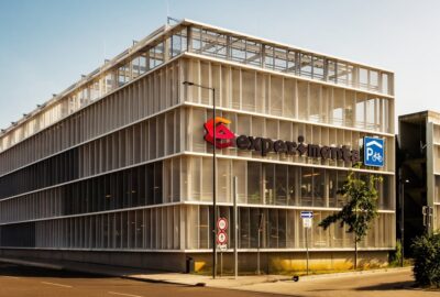Das Foto zeigt das Experimenta Parkhaus, ein großes Geschäftsgebäude in Heilbronn. Das Gebäude betont moderne Architektur und ist für den Außenbereich konzipiert.