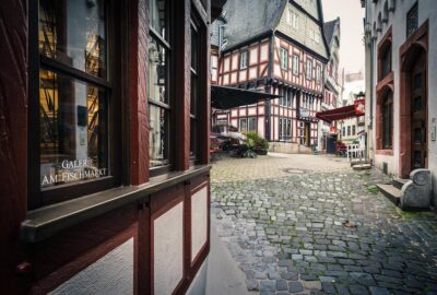 Das Bild zeigt eine bezaubernde Straße in Limburg an der Lahn, Deutschland, mit Gebäuden entlang einer schmalen Kopfsteinpflasterstraße.
