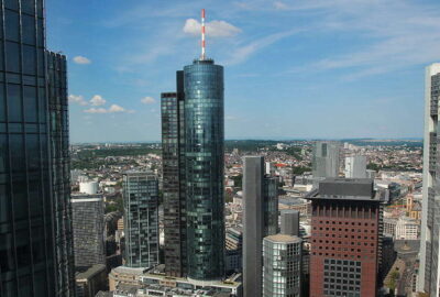 Der Standort ist der Main Tower mit Aussichtsplattform in Frankfurt. Das Bild zeigt eine Stadt mit hohen Gebäuden und zeigt eine Stadtlandschaft mit Wolkenkratzern und einer Metropolregion.